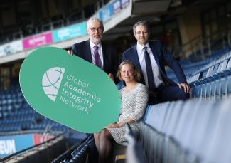 QQI CEO, Padraig Walsh; Helen Gniel, Director, TEQSA Higher Education Integrity Unit and Mr Simon Harris TD, Minister for Further and Higher Education, Research, Innovation and Science holding a Global Academic Integrity Network sign at the launch of the network in Croke Park. 