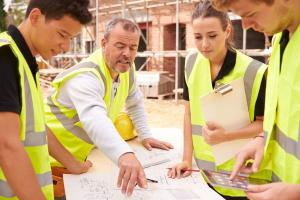 Workers looking at plans on construction site