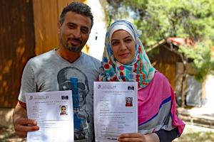 Refugees, one man and one woman, each holding an EQPR. Copyright Council of Europe, photo Gloria Mannazzu